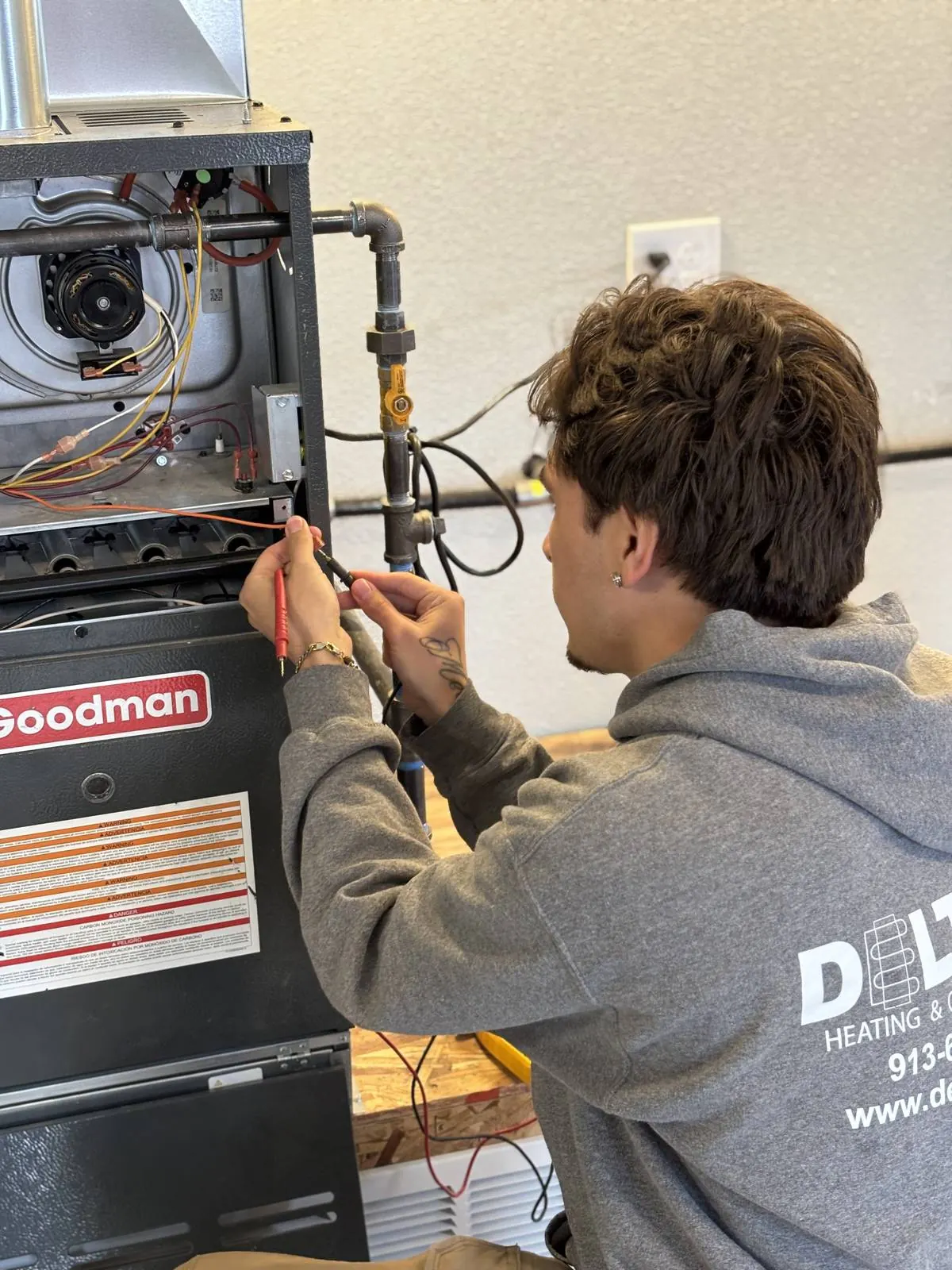 Delta T technician inspecting an open furnace